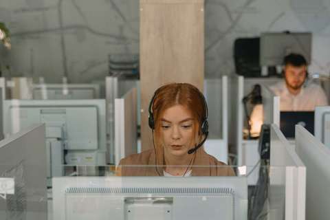 Operadora con auriculares en su box de un centro de llamadas
