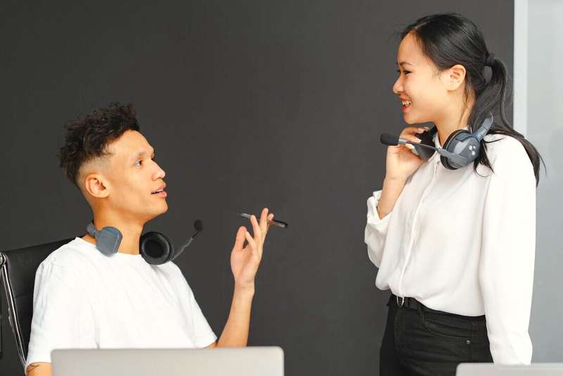 Operador y supervisora conversando en una oficina con auriculares