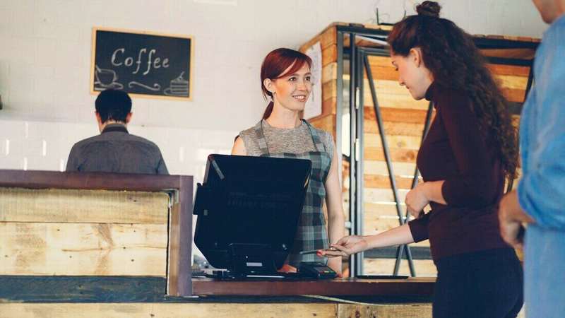 Dos mujeres atendiendo en el mostrador de una cafetería
