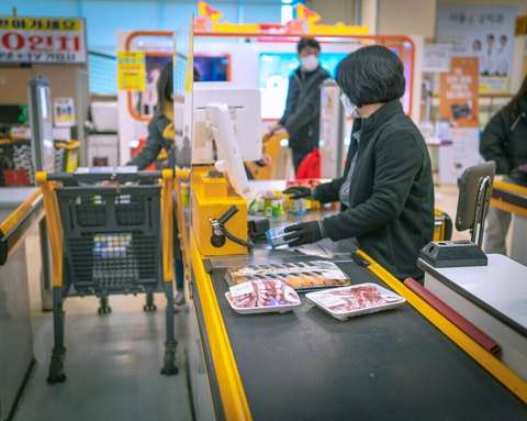Cajera en la línea de cajas de un supermercado