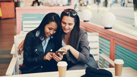 Dos amigas mirando un celular juntas