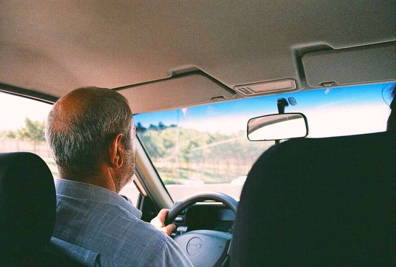 Conductor mayor mirando el camino desde el asiento