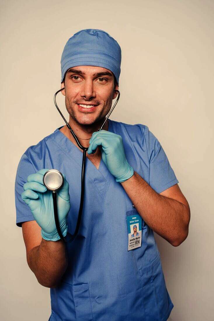 Enfermero con gorro y guantes sonriendo con un estetoscopio