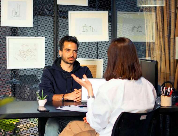 Dos personas conversando en un escritorio