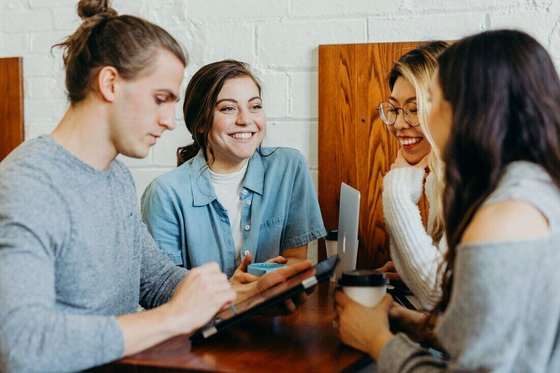 Amigos conversando en un café con un celular