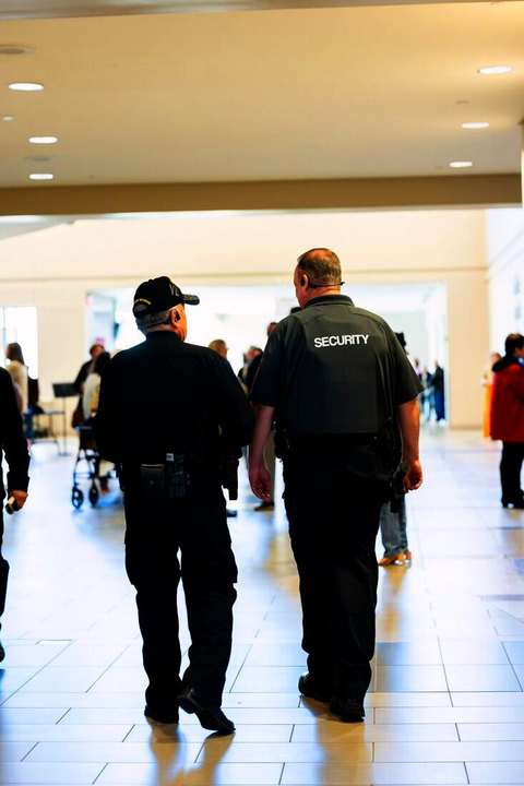 Dos guardias de seguridad caminando por un pasillo de un centro comercial
