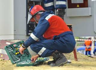 Técnico de mantenimiento agachado junto a una caja de herramientas