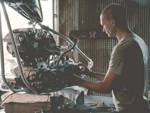 Mecánico trabajando en el motor de una moto en un taller