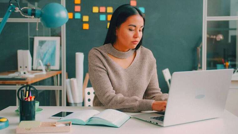 Mujer trabajando con una notebook en un escritorio