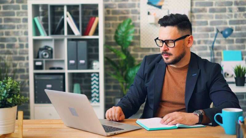 Hombre con anteojos trabajando en una notebook