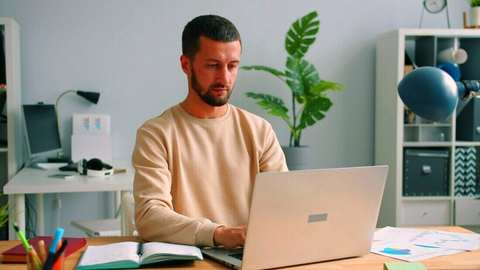Hombre trabajando con una notebook en un escritorio con plantas
