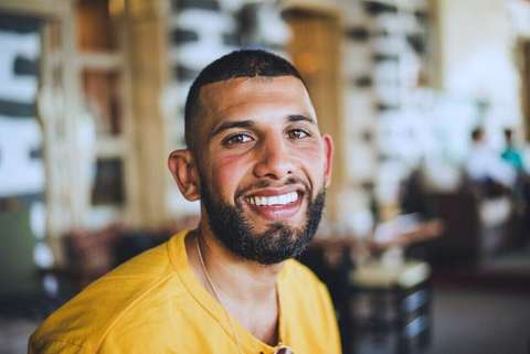 Hombre sonriendo con remera amarilla