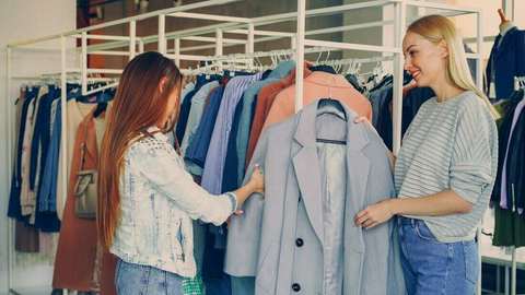 Dos mujeres mirando un saco en un local de ropa