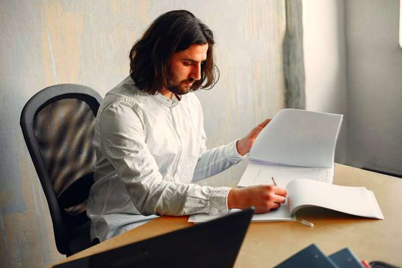 Hombre revisando hojas impresas en un escritorio